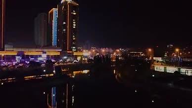 无人机夜间水面升起大楼视频的预览图